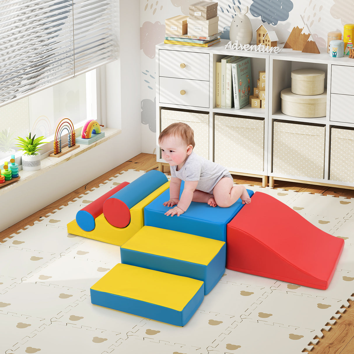 Baby playing on colorful foam blocks in a room with shelves and toys.