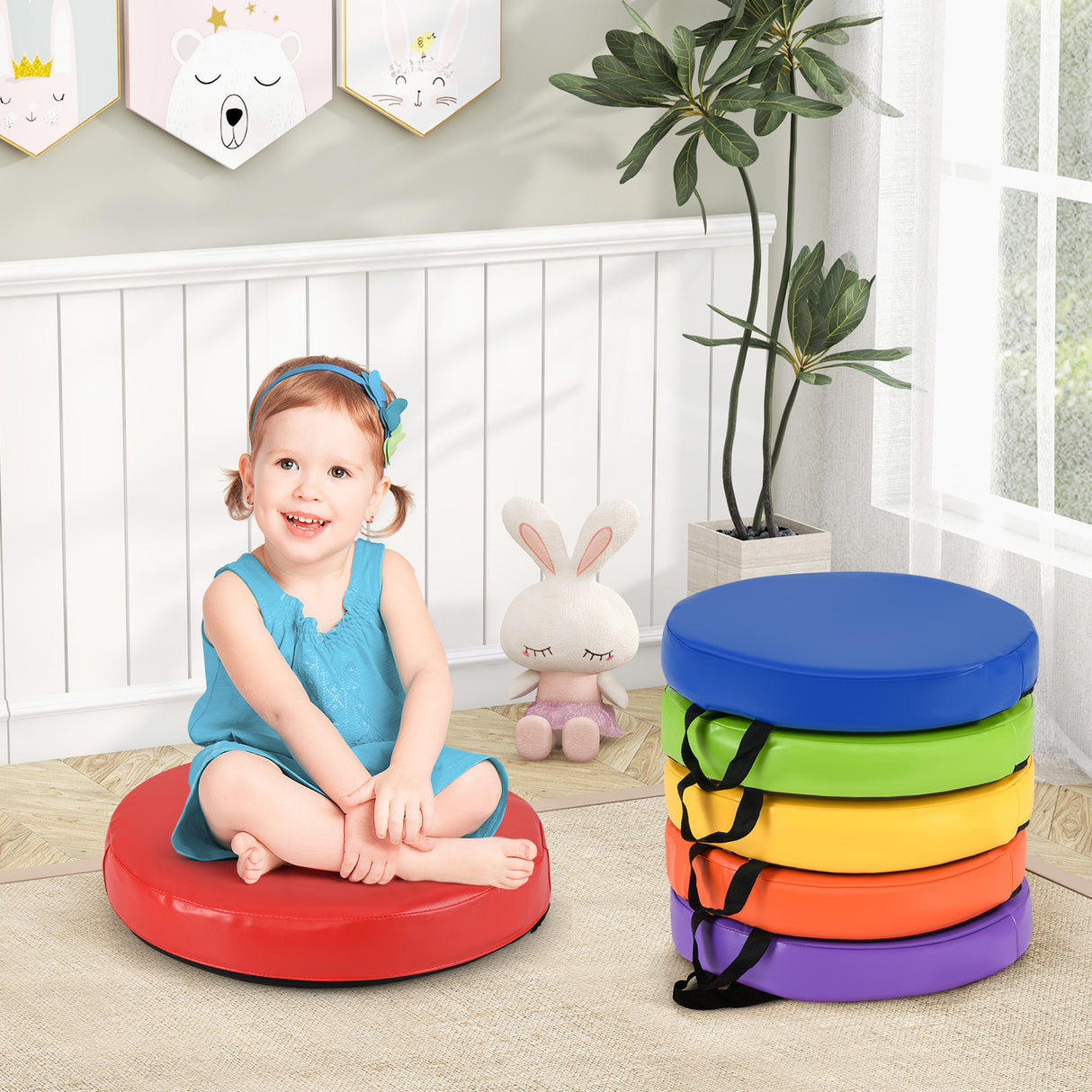 Child sitting on a colorful stool with a stack of rainbow-colored stools in front