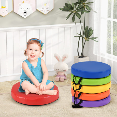 Child sitting on a colorful stool with a stack of rainbow-colored stools in front