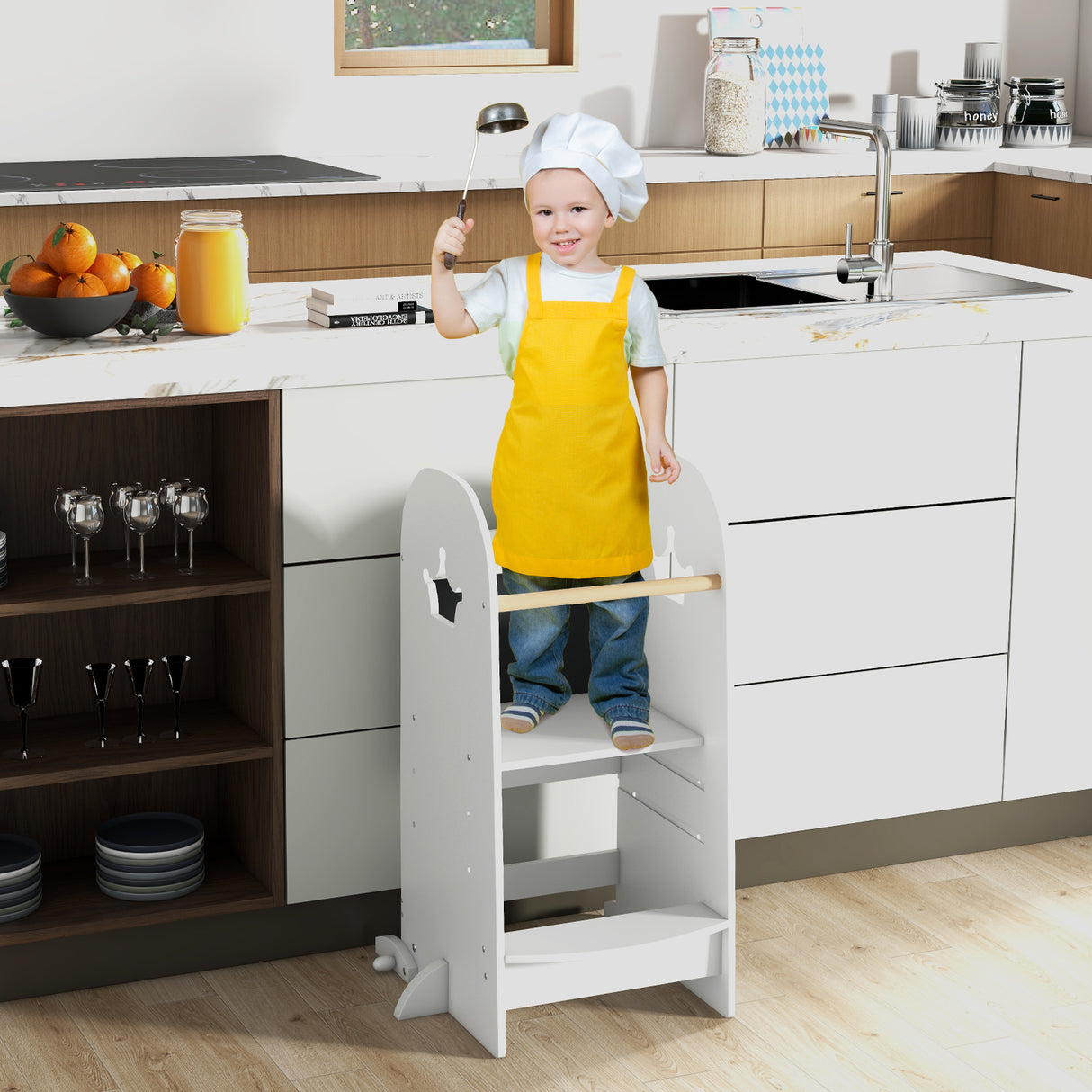 Child standing on a step stool in a kitchen wearing a yellow apron.