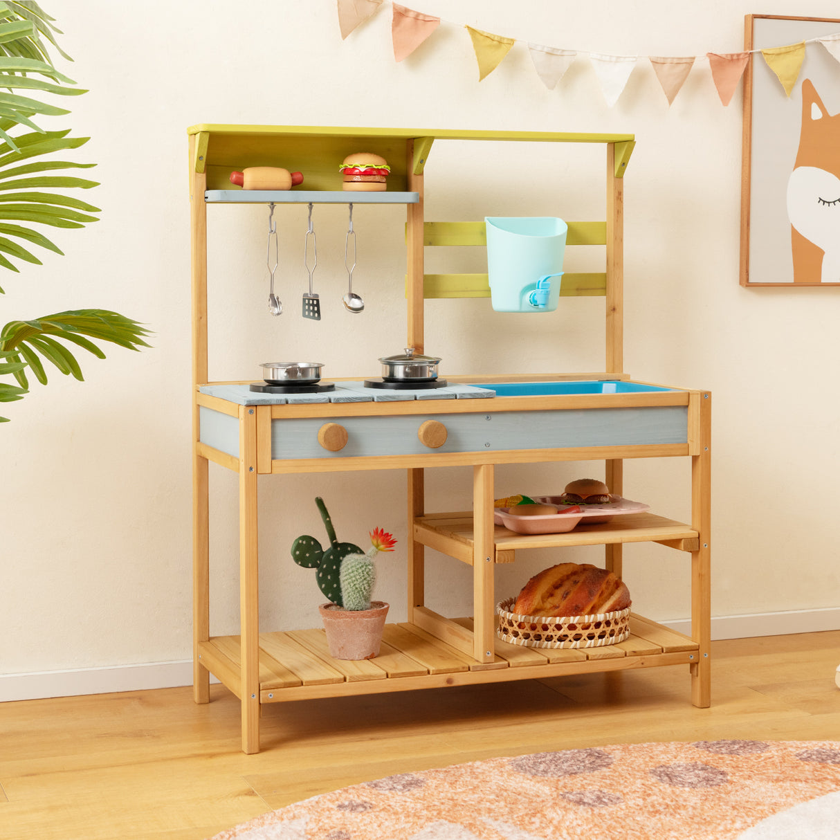 Children's play kitchen set with wooden shelves and toy food items on a light-colored floor.