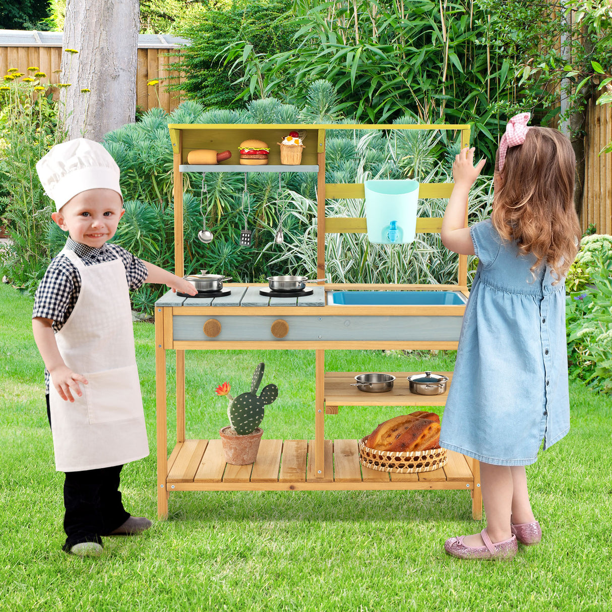 Two children playing with a wooden play kitchen set outdoors.