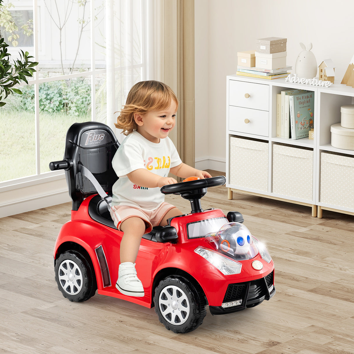 Child sitting in a red toy car indoors