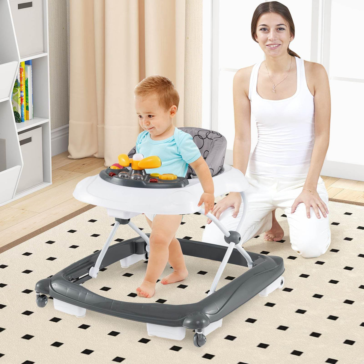 Child using a baby walker with a woman sitting on the floor nearby.