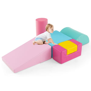 A set of colorful foam play blocks arranged on the floor with a toddler lying on top of a pink wedge block.
