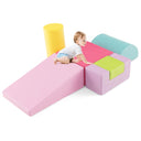 A set of colorful foam play blocks arranged on the floor with a toddler lying on top of a pink wedge block.