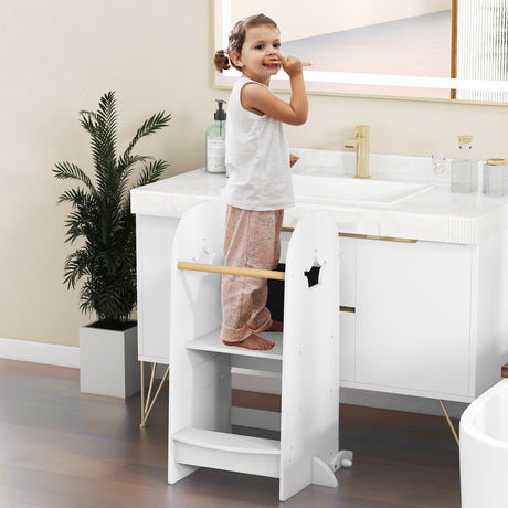 Child standing on a step stool in a bathroom with a sink and plant in the background.