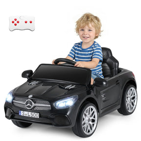Child sitting in a toy Mercedes-Benz car with a remote control on a white background