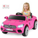 Child sitting in a pink toy car with a remote control on a white background