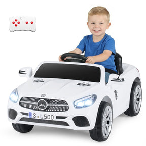 Child sitting in a white toy Mercedes-Benz car with a remote control on a white background